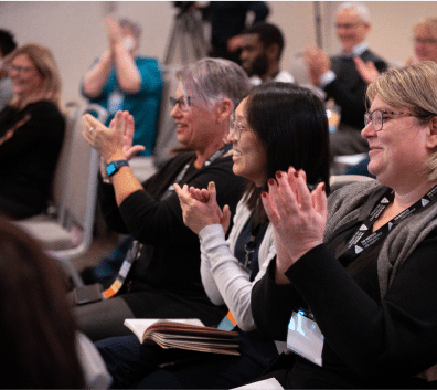 Audience members seated and clapping during a facilitation training session