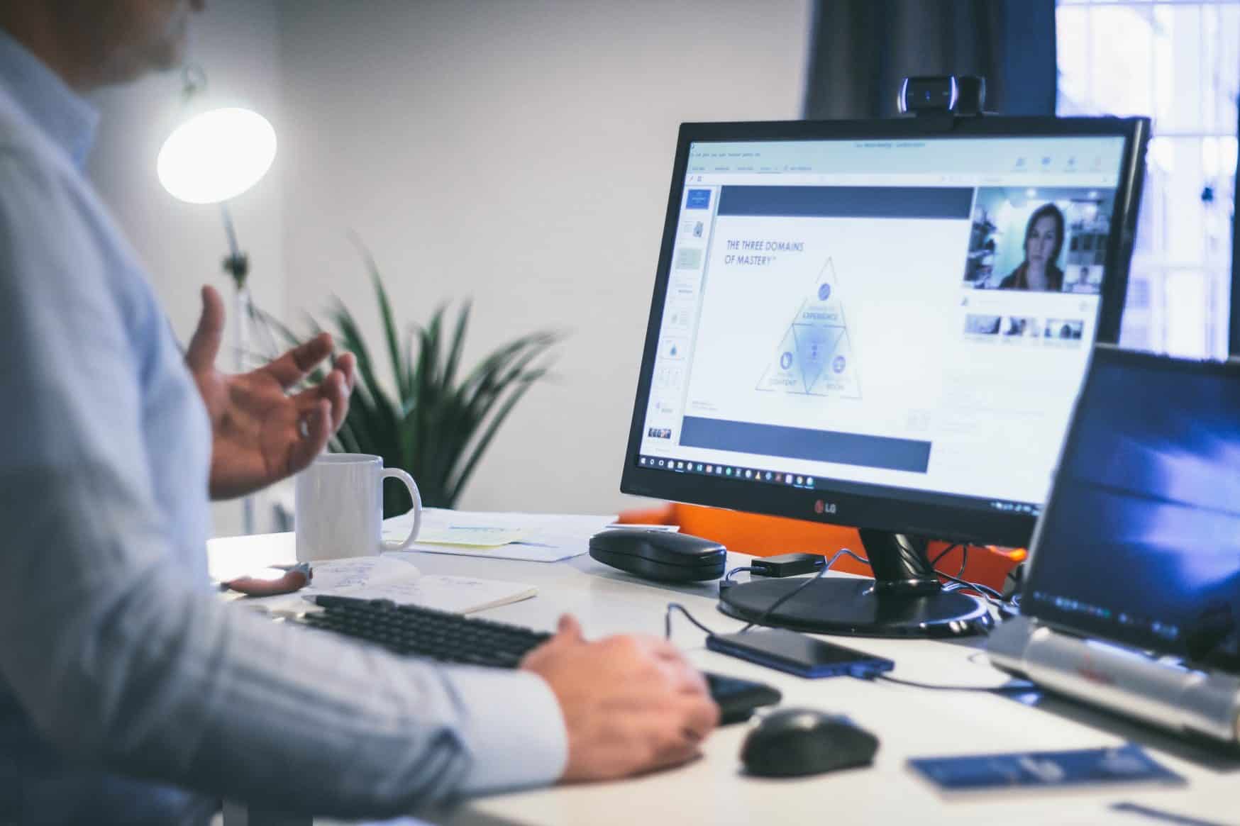 worker reading about three domains of mastery on his laptop while virtually connected